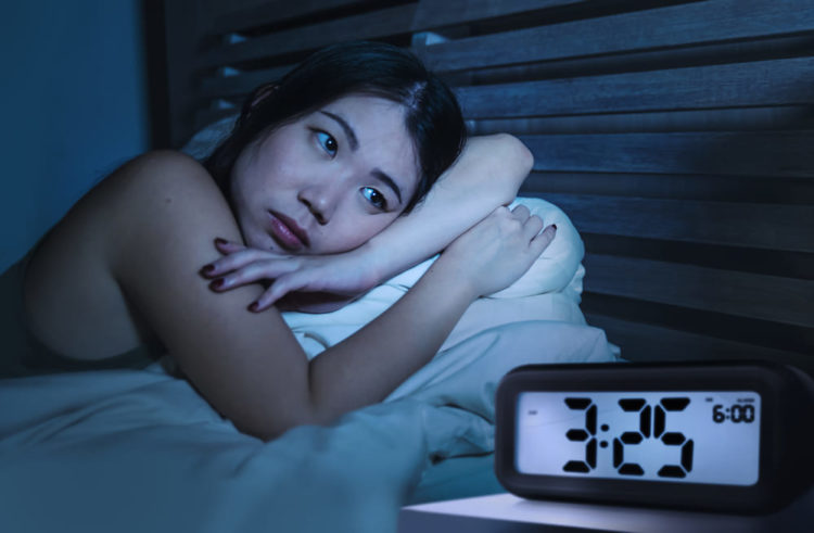 woman sleeping with alarm clock